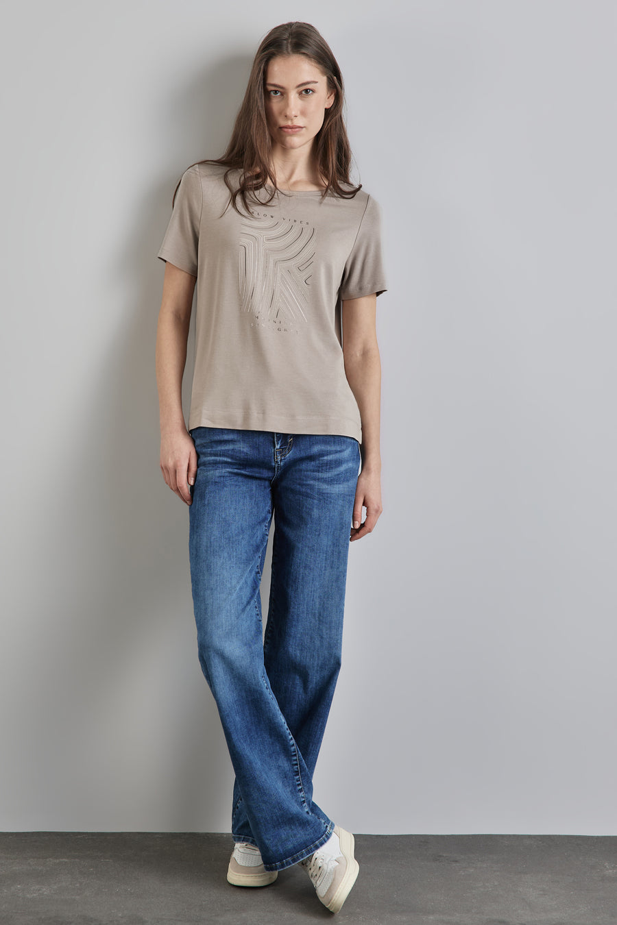 Top uni manches courtes beige de Street One avec motif décoratif sur le devant, porté avec un jean bleu et des baskets.
