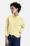 Gele sweater, van STREET ONE, met reliëftekstpatroon, gedragen met een blauwe jeans en witte sneakers.
