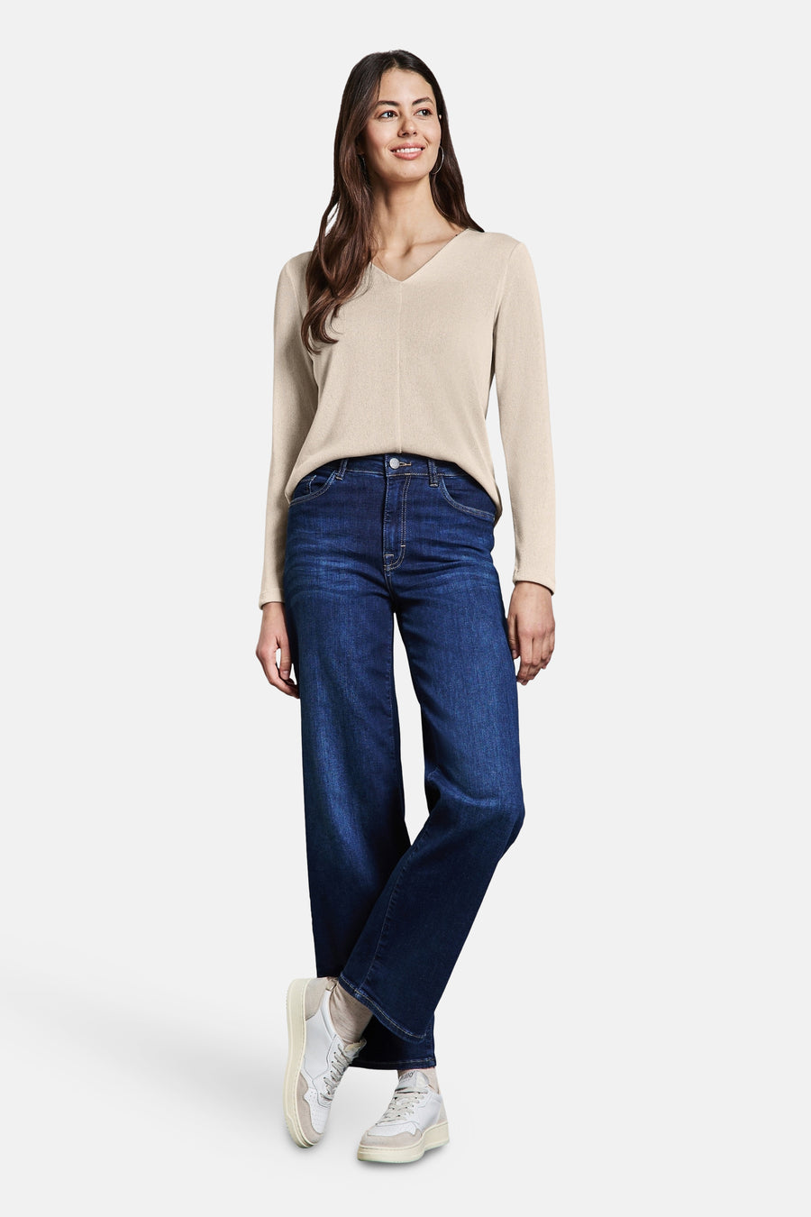 Top uni manches longues beige de Street One, porté avec un jean large bleu foncé et des baskets blanches.
