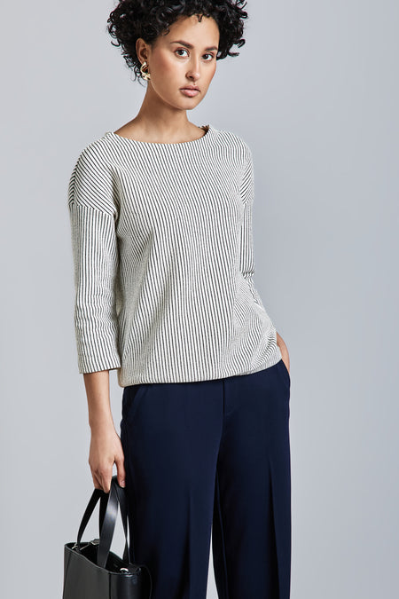 Wit gestreept zwart T-shirt met lange mouwen van Street One, gedragen met een wijde marineblauwe broek en een zwarte tas.