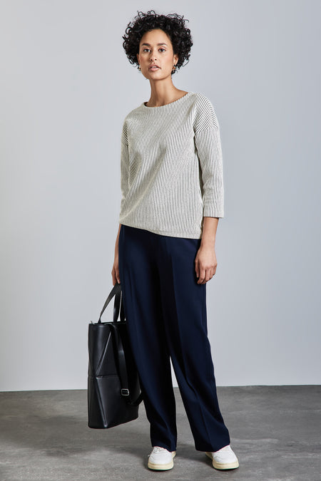 T-shirt à manches longues blanc rayé noir de Street One, porté avec un pantalon bleu marine ample et un sac noir.
