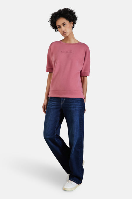 Top met korte mouwen koraal van STREET ONE, gedragen met een donkerblauwe wijde jeans en witte sneakers.