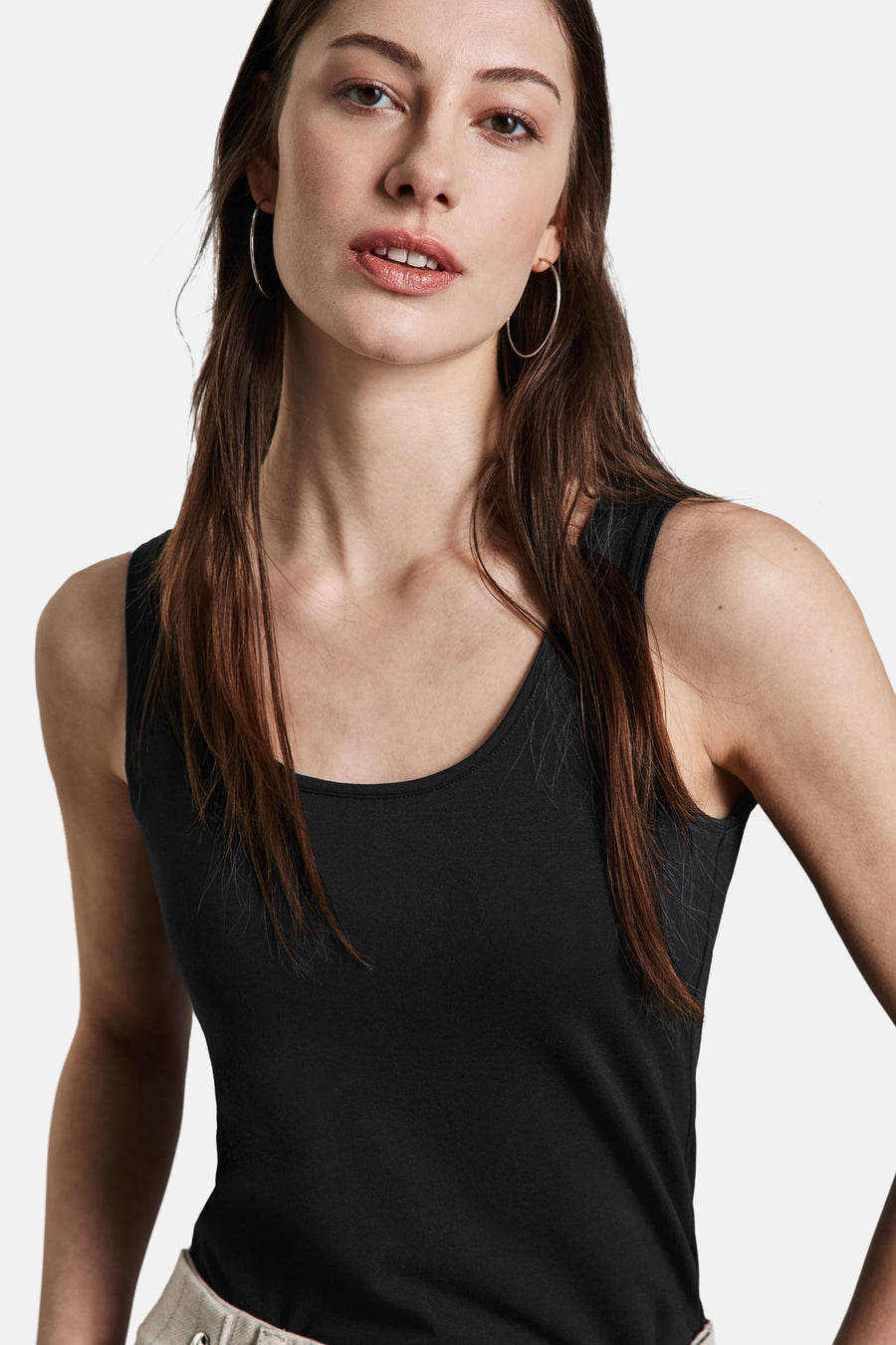 Zwart hemdje van Street One, gedragen met een gestreepte jas en broek, en witte sneakers.