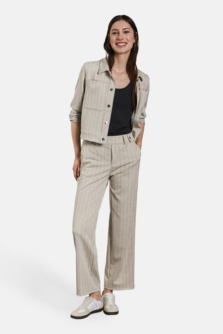 Débardeur noir de Street One, porté avec une veste et un pantalon rayés, et des baskets blanches.