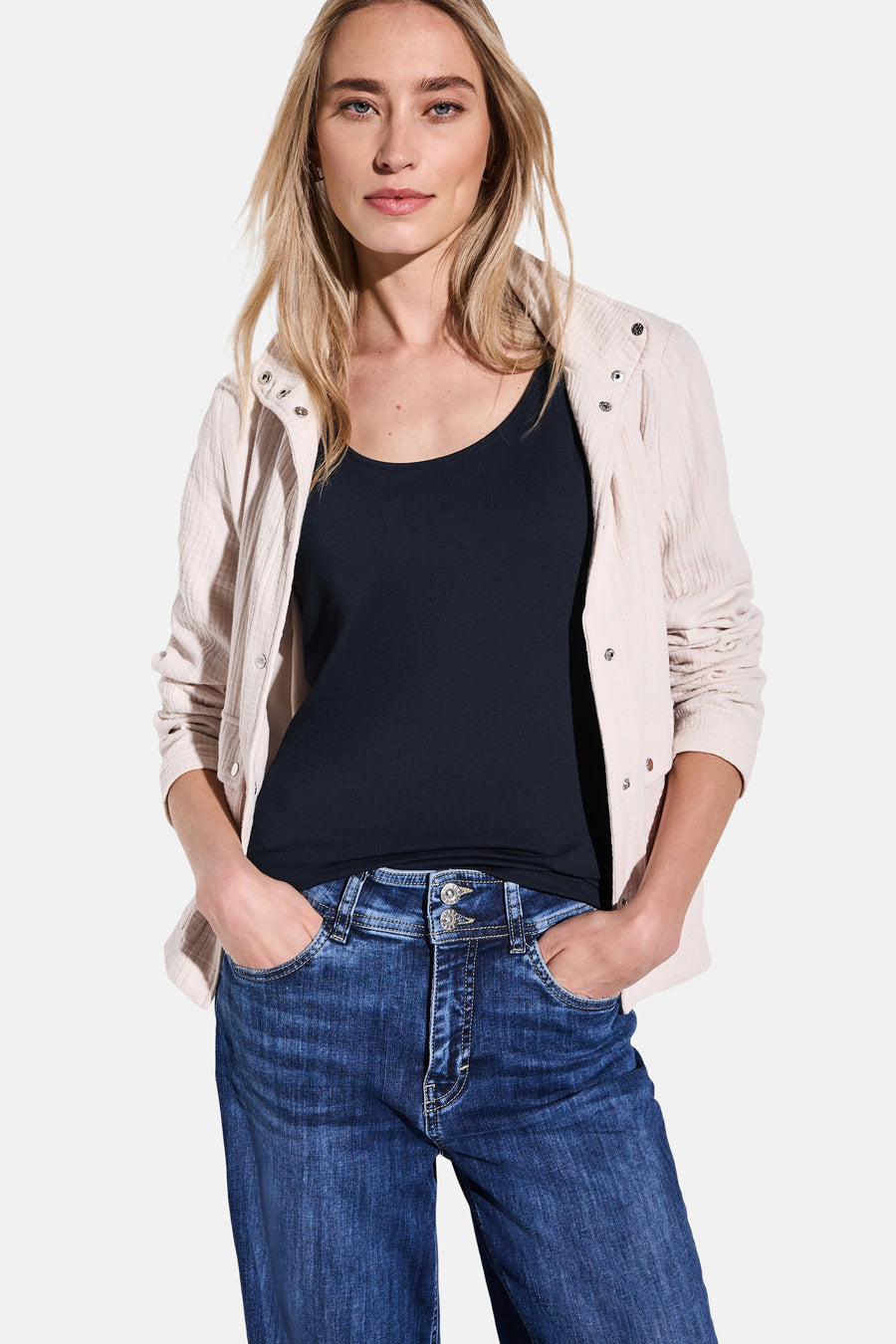 Blauwe tanktop van STREET ONE, gedragen met een beige textuurjasje en een casual spijkerbroek.