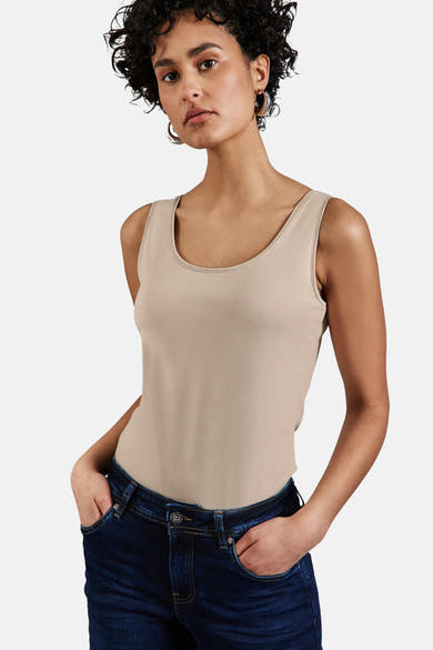 Beige tanktop van STREET ONE, gedragen met een donkerblauwe jeans en zilveren oorbellen.