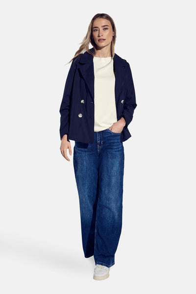 Top met korte mouwen wit van Street One, gedragen met een blauwe jas en een wijde jeans.