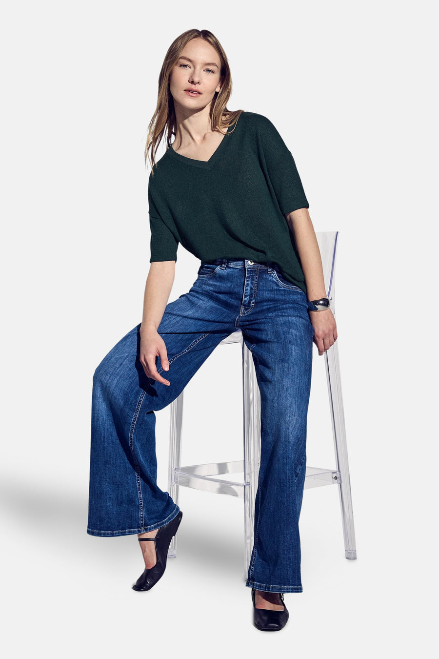 T-shirt vert en maille, par STREET ONE, avec un col en V et manches courtes, porté avec un jean taille haute.
