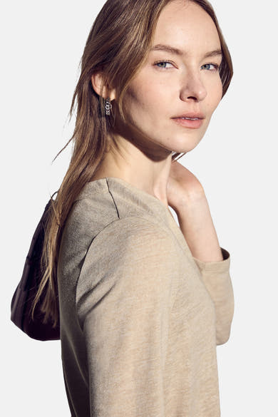 Top met lange mouwen beige van Street One, gedragen met zilveren oorbellen.