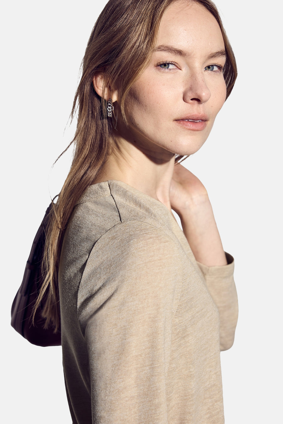 Top met lange mouwen beige van Street One, gedragen met zilveren oorbellen.