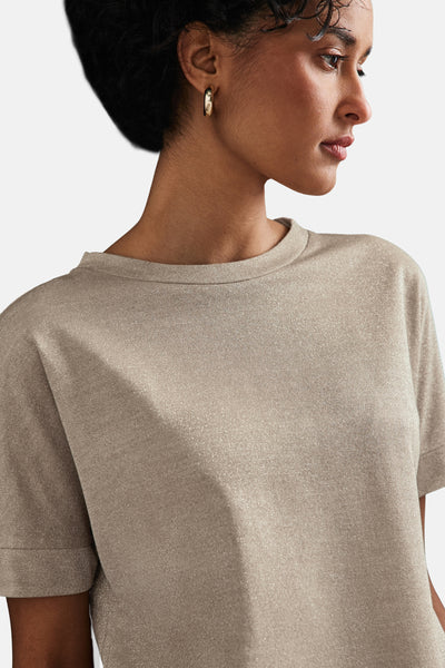Top uni à manches courtes beige de STREET ONE, en maille brillante, porté avec des boucles d'oreilles dorées.
