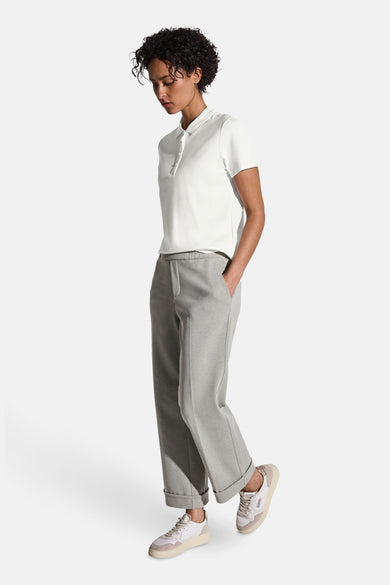 Polo écru de STREET ONE, avec une patte de boutonnage et porté avec un pantalon gris et des baskets.
