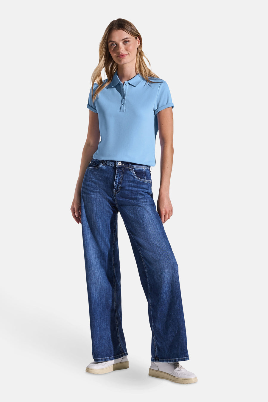 Polo bleu clair de STREET ONE porté avec un jean large et des baskets blanches.
