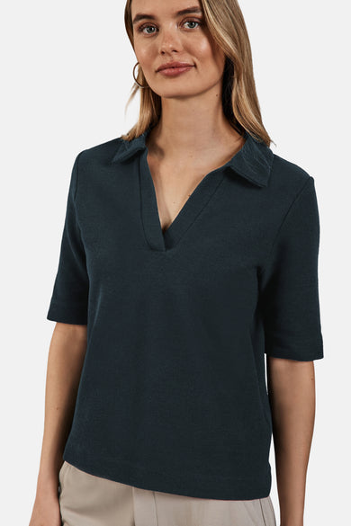 Polo groen van STREET ONE, met klassieke collar en korte mouwen, gedragen met oorhangers.
