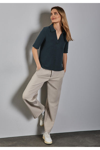 Polo groen van STREET ONE, gedragen met een beige broek en witte sportlaarzen.