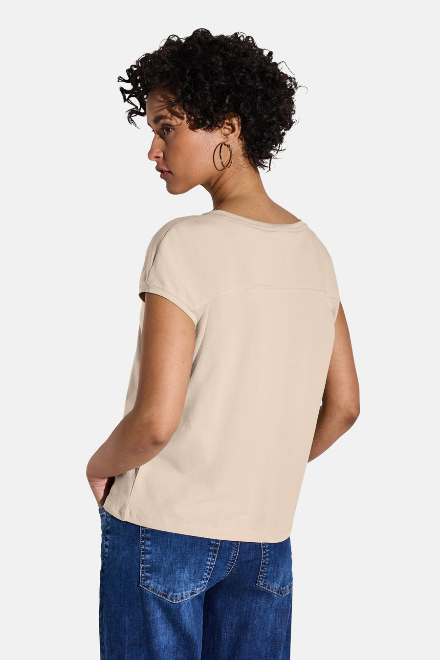 Beige T-shirt met korte mouwen van STREET ONE, gedragen met een blauwe spijkerbroek en ronde oorbellen.
