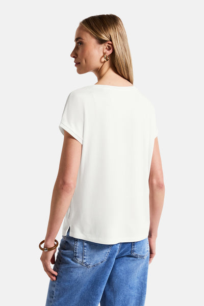 Top met korte mouwen wit van Street One, gedragen met een spijkerbroek en een bruine armband.