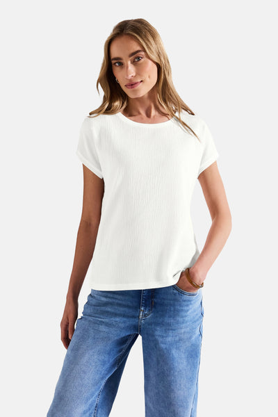 Top uni manches courtes blanc de Street One, porté avec un jean bleu et un bracelet.
