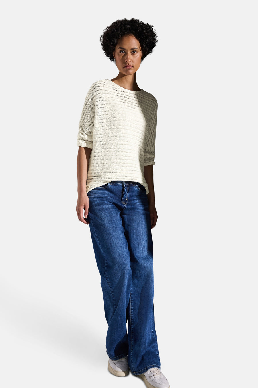 Pull col rond blanc en maille ajourée de STREET ONE, porté avec un jean ample et des baskets.

