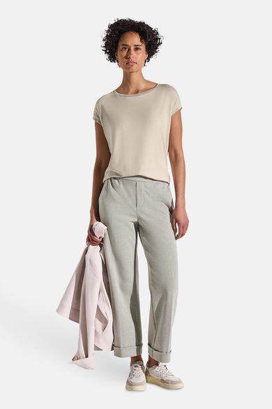 Top eenarmige beige jurk van STREET ONE, gedragen met een ruime grijs broek en sneakers.