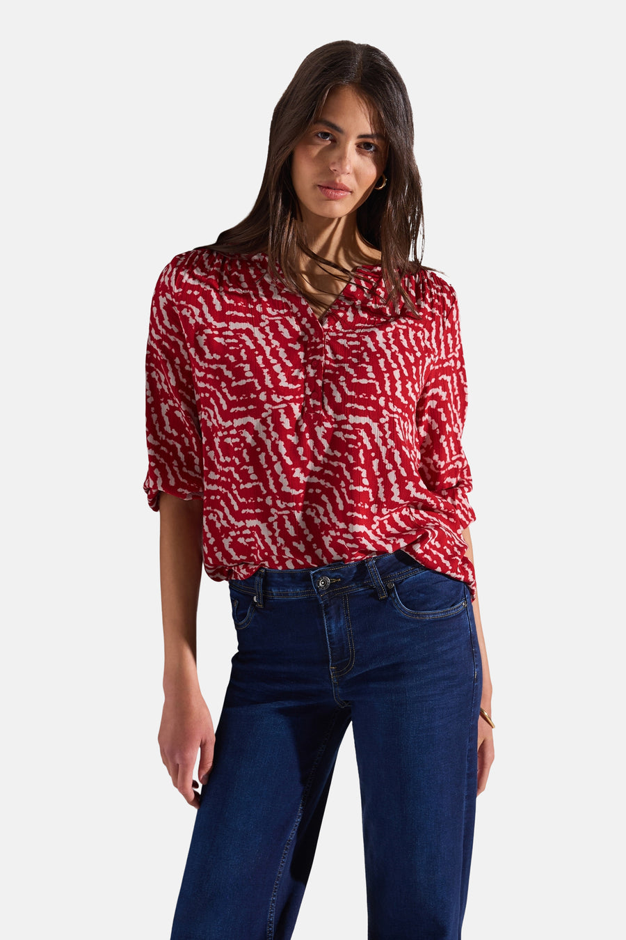 Chemisier à manches longues multicolore de Street One avec motif abstrait rouge et pantalon bleu foncé.