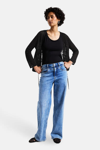 Zwarte Street One bodywarmer met een open patroon, gedragen over een zwart T-shirt en een blauwe jeans.