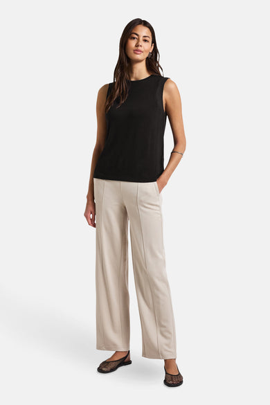 Top sans manches noir de STREET ONE, porté avec un pantalon beige ample et des ballerines à résille.
