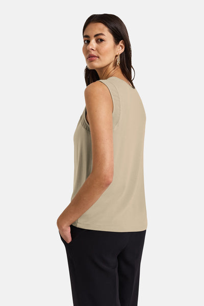 Beige mouwloze top van Street One, gedragen met een zwarte broek en gouden oorbellen.