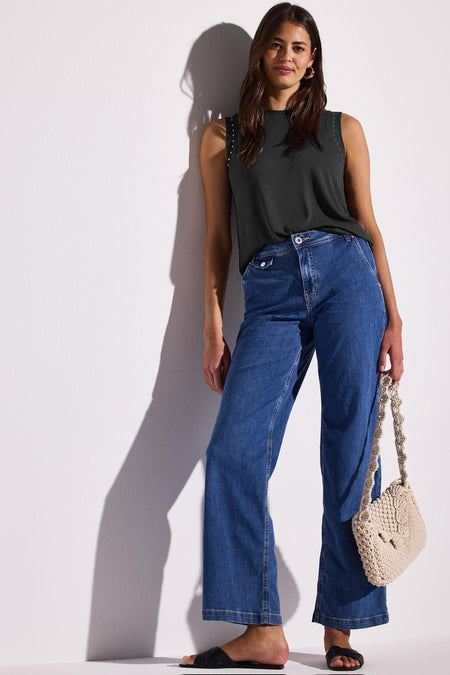 Grijs mouwloos topje van Street One, gedragen met een blauwe jeans en een macramé tas.