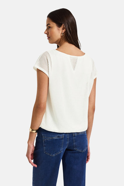Top uni manches courtes blanc de STREET ONE, avec un motif ajouré, porté avec un jean bleu et un bracelet doré.
