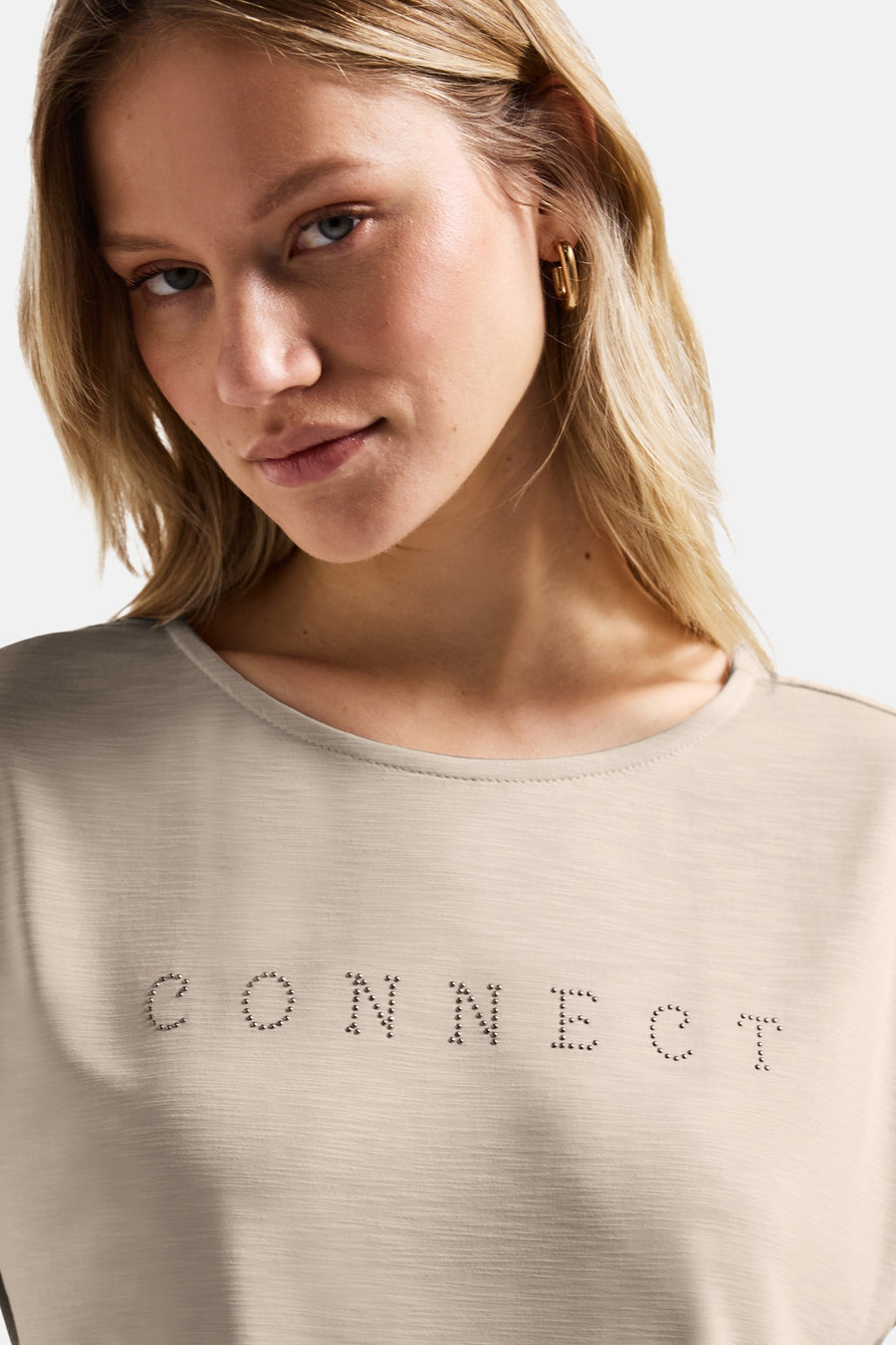 Top uni manches courtes beige de STREET ONE, orné de strass formant le mot « CONNECT », porté avec des boucles d'oreilles dorées.
