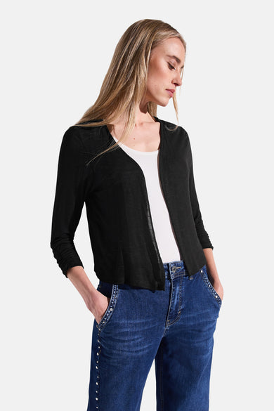 Zwarte gilet van Street One, gedragen over een witte tanktop en een spijkerbroek met klinknagels.