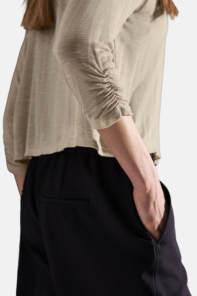Gilet beige de STREET ONE, manches longues froncées, porté avec un pantalon noir à poches.