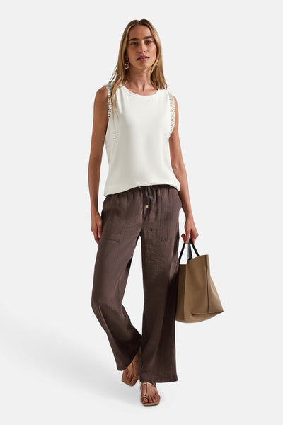 Ecru mouwloos top van Street One, met ajourdetails op de schouders, gedragen met een bruine broek en een beige tas.