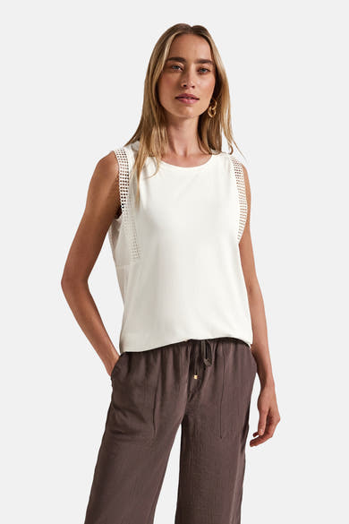 Top sans manches écru de Street One, avec détails ajourés sur les épaules et porté avec un pantalon marron.