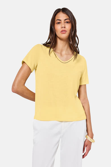 Top met korte mouwen geel van Street One, versierd met een ajourrandje bij de hals, gedragen met een witte broek.