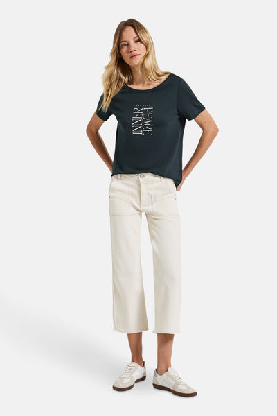 Groen T-shirt met korte mouwen van STREET ONE met witte tekstprint, gedragen met een gebroken witte broek en sneakers.