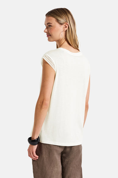 Wit mouwloos topje van STREET ONE, met gehaakte inzetten op de schouders en gedragen met een zwarte armband.