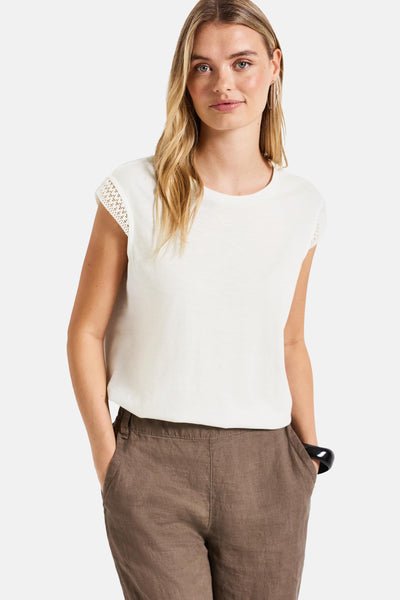 Top sans manches blanc de Street One, avec des détails en dentelle aux épaules et porté avec un pantalon marron.
