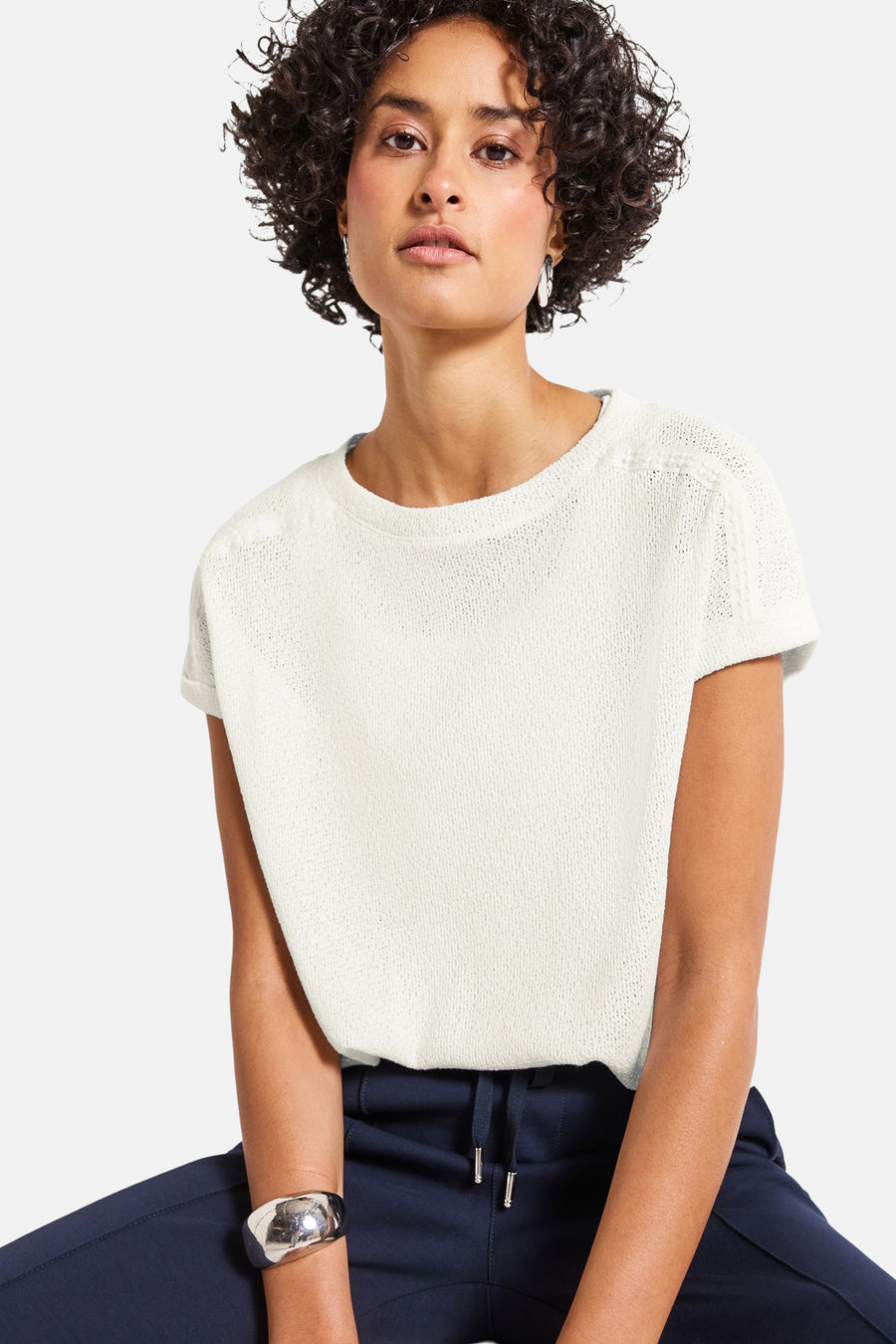 Top met korte mouwen in wit van Street One, gedragen met een marineblauwe broek en een zilveren armband.