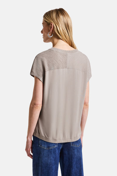 Top uni manches courtes beige de Street One, avec empiècement texturé et porté avec un jean.

