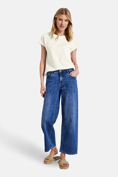 Top met korte mouwen wit van STREET ONE, gedragen met een wijde blauwe jeans en gevlochten sandalen.