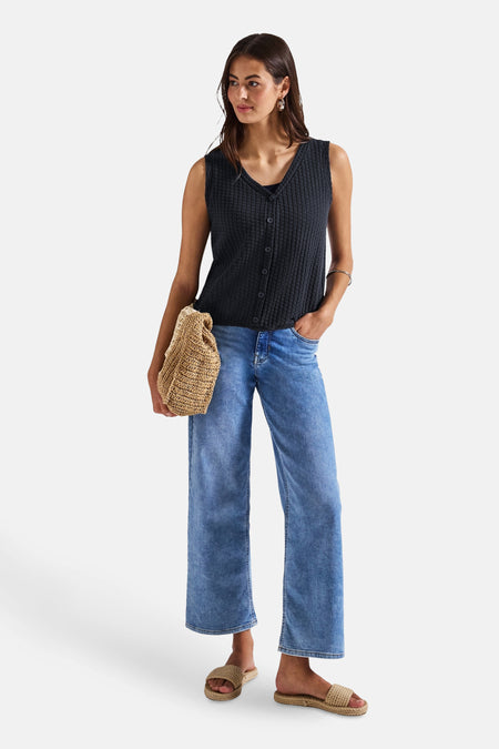 Blauw mouwloos topje van STREET ONE, gedragen met een wijde jeans en gevlochten sandalen, met een rieten tas.