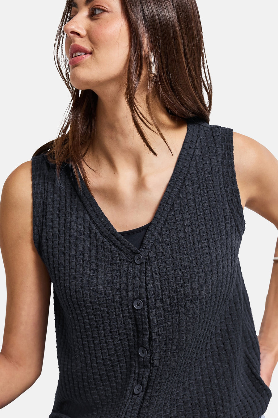 Blauw mouwloos topje van STREET ONE, in wafelbreisel met knopen, gedragen over een zwart hemdje.