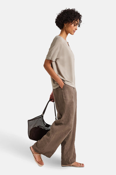 Top uni manches courtes beige de STREET ONE, porté avec un pantalon marron ample et un sac en filet noir.