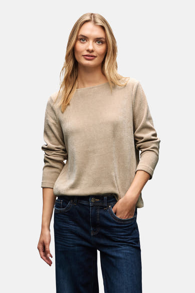 Top uni manches longues beige de Street One, porté avec un jean brut bleu foncé.