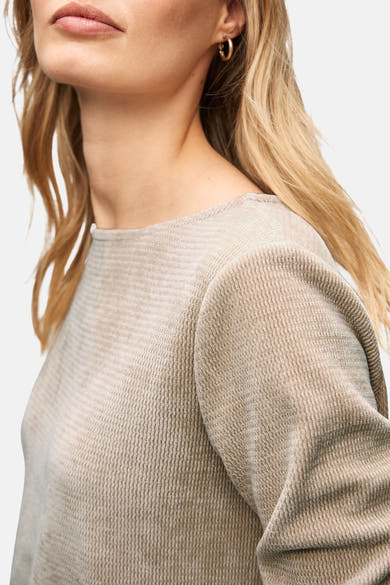 Top uni beige à manches longues de STREET ONE, détail texturé, porté avec des boucles d'oreilles dorées.