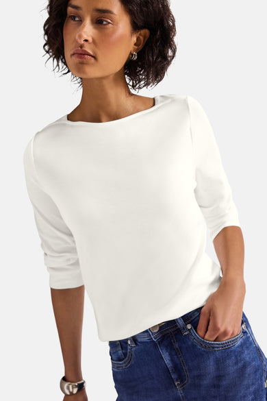 Top uni manches longues blanc de STREET ONE, porté avec un jean et des boucles d'oreilles.
