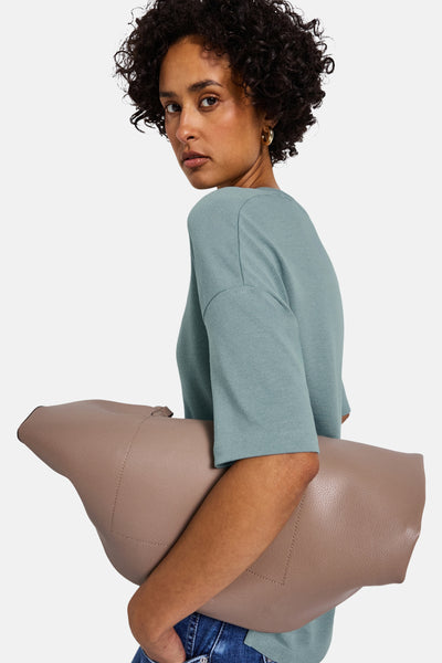 Blauwe V-hals trui van Street One, gedragen met een spijkerbroek en gouden oorbellen.