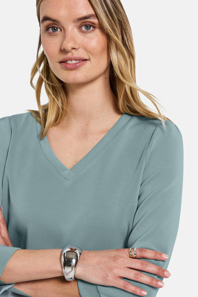 Blauwe trui van STREET ONE met V-hals, lange mouwen en gedragen door een vrouw met sieraden.